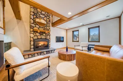 a living room with a fireplace and a couch at The Haüs Windham - Spacious Suites, Hot Tub, Mountain Views! in Windham