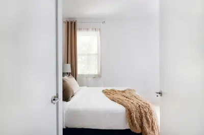 a bedroom with a bed with white sheets and a window at 78-4A 2BR Duplex with a Balcony Prime UES in New York
