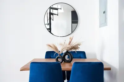 a dining room table with blue chairs and a mirror at 78-4A 2BR Duplex with a Balcony Prime UES in New York