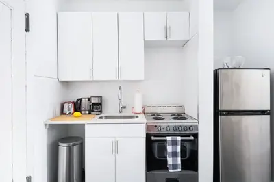 a kitchen with white cabinets and a stove top oven at 444-2C Newly renovated 1BR in Hell's Kitchen in New York