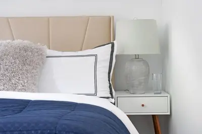 a bed with a blue blanket and a lamp on a night stand at 444-4F Newly renovated 1BR in Midtown West in New York