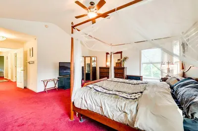 a bedroom with a canopy bed and a red carpet at Woodsy Ballston Spa Home 4 Mi to State Park! in Ballston Spa