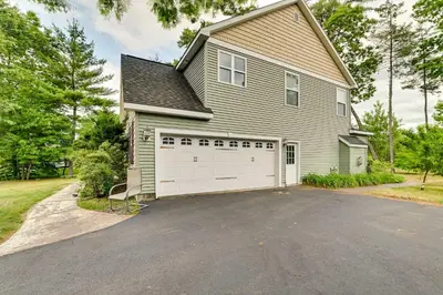 a house with a white garage and a driveway at Woodsy Ballston Spa Home 4 Mi to State Park! in Ballston Spa