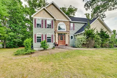 a house with a red door on a yard at Woodsy Ballston Spa Home 4 Mi to State Park! in Ballston Spa