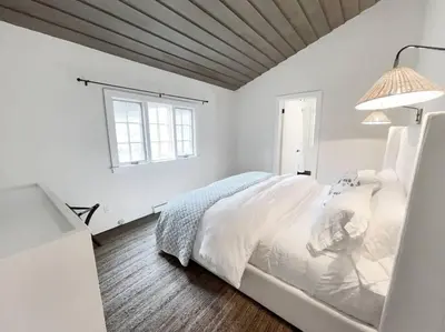 a white bedroom with a bed and a window at Cottage Retreat - Historic Cottage Home w Home Gym in Cornwall