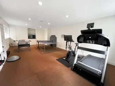 a living room with a treadmill and a ping pong table at Cottage Retreat - Historic Cottage Home w Home Gym in Cornwall