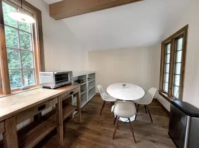 a kitchen with a table with a microwave and chairs at Cottage Retreat - Historic Cottage Home w Home Gym in Cornwall