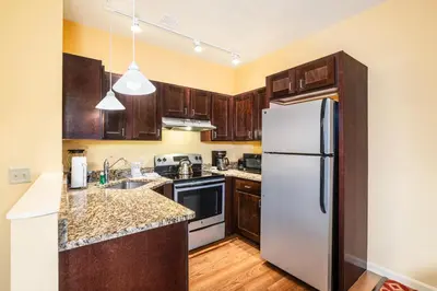 a kitchen with wooden cabinets and a white refrigerator at Berkshire Mountain Lodge in Pittsfield