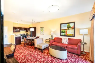 a living room with red furniture and a kitchen at Berkshire Mountain Lodge in Pittsfield