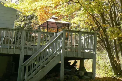 a wooden deck with a gazebo next to a house at Catskill Mountain Retreat in West Kill