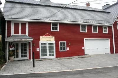 a red building with a garage in front of it at Visions Inn in Cooperstown