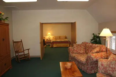 a living room with a couch and a bed at Visions Inn in Cooperstown
