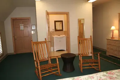 a room with two chairs and a bed and a sink at Visions Inn in Cooperstown