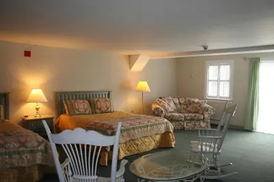 a hotel room with a bed and a couch at Visions Inn in Cooperstown