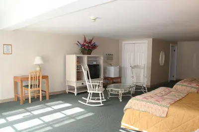 a hotel room with a bed and a table and chairs at Visions Inn in Cooperstown