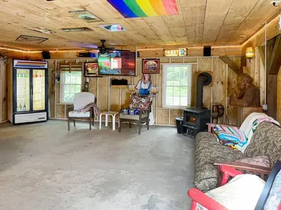 a woman standing in a living room with a rainbow ceiling at Haven Retreat in Catskills w Hot Tub & Bar Hall in Sundown