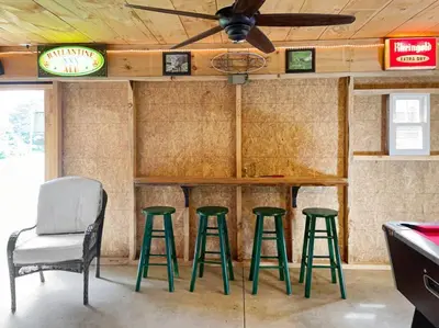 a bar in a room with four green stools at Haven Retreat in Catskills w Hot Tub & Bar Hall in Sundown