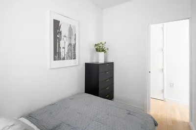 a bedroom with a bed and a dresser with a plant on it at Beautiful 2BD with a Gym near Times Square in New York