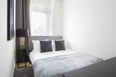 a bedroom with a white bed with pillows and a window at Stylish 2BD with Washer and Dryer near Times Square in New York