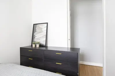 a bedroom with a dresser with a mirror on it at Stylish 2BD with Washer and Dryer near Times Square in New York