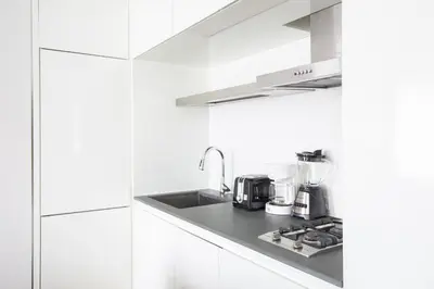 a white kitchen with a sink and a stove at Perfectly located 2BD near Times Square with Gym in New York