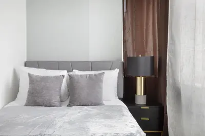 a bedroom with a bed with pillows and a lamp at Perfectly located 2BD near Times Square with Gym in New York