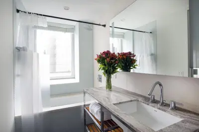 a bathroom with a sink and a vase of flowers at Beautiful 2BD Apartment near Times Square in New York