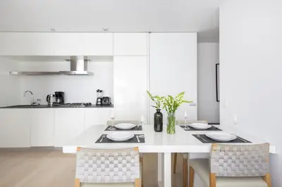 a white kitchen with a white table and chairs at Modern 2BD in Midtown with Washer and Dryer in-unit in New York