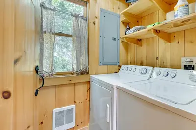 a laundry room with a washer and dryer and a window at Lakefront Westhampton Cabin with Beach and Kayaks! in Westhampton