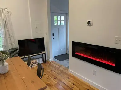 a living room with a table and a fireplace at Campfire Cottage Fireplace, fire pit & no chores! in Kingston