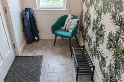 a green chair in a room with a wall at Campfire Cottage Fireplace, fire pit & no chores! in Kingston