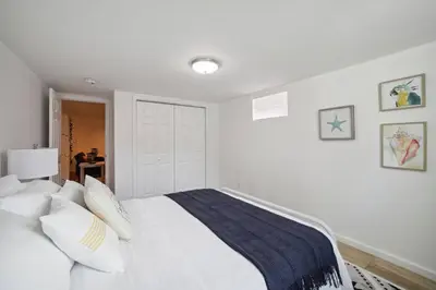 a white bedroom with a large bed with white pillows at Marine Theme - 4 BR - Backyard - Fire pit in Bridgeport