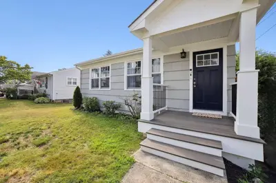 a white house with a blue door and a yard at Marine Theme - 4 BR - Backyard - Fire pit in Bridgeport