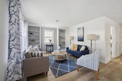 a living room with a blue couch and a table at Marine Theme - 4 BR - Backyard - Fire pit in Bridgeport
