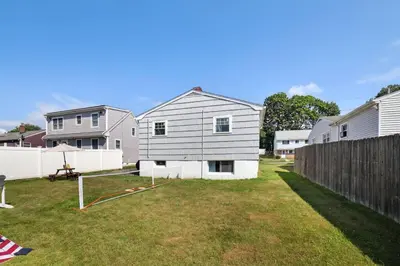 a house in a yard next to a fence at Marine Theme - 4 BR - Backyard - Fire pit in Bridgeport