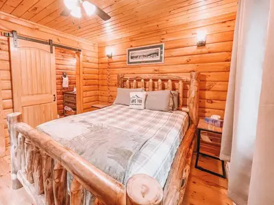 a bedroom with a bed in a log cabin at Mountain-Top-Hideaway Stay in a log cabin on a private rd! Swim, hike, explore a true mountain experience in North Blenheim
