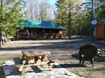 a picnic table and a fire hydrant in front of a cabin at Mountain-Top-Hideaway Stay in a log cabin on a private rd! Swim, hike, explore a true mountain experience in North Blenheim