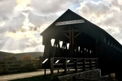 a large black barn with a sign on it at Mountain-Top-Hideaway Stay in a log cabin on a private rd! Swim, hike, explore a true mountain experience in North Blenheim