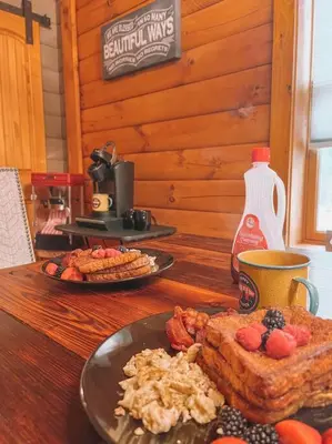 a wooden table with a plate of food on it at Mountain-Top-Hideaway Stay in a log cabin on a private rd! Swim, hike, explore a true mountain experience in North Blenheim