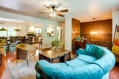 a living room with a blue couch and a dining room at Game Room and Hot Tub Ski Getaway in Poconos! in East Stroudsburg