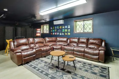 a living room with a brown leather couch and a table at Game Room and Hot Tub Ski Getaway in Poconos! in East Stroudsburg