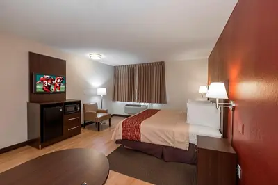 a hotel room with a bed and a table at Red Roof Inn PLUS+ Poughkeepsie in Poughkeepsie