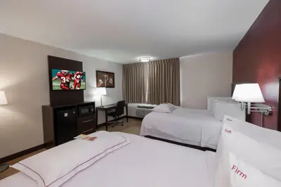 a hotel room with two beds and a desk at Red Roof Inn PLUS+ Poughkeepsie in Poughkeepsie