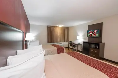 a hotel room with two beds and a flat screen tv at Red Roof Inn PLUS+ Poughkeepsie in Poughkeepsie