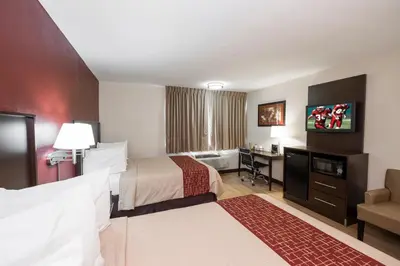 a hotel room with two beds and a desk at Red Roof Inn PLUS+ Poughkeepsie in Poughkeepsie