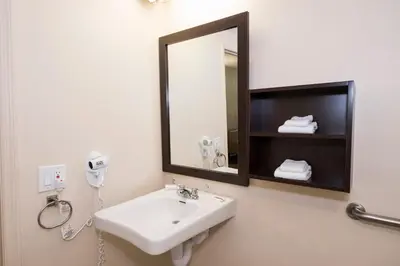 a bathroom with a sink and a mirror at Red Roof Inn PLUS+ Poughkeepsie in Poughkeepsie
