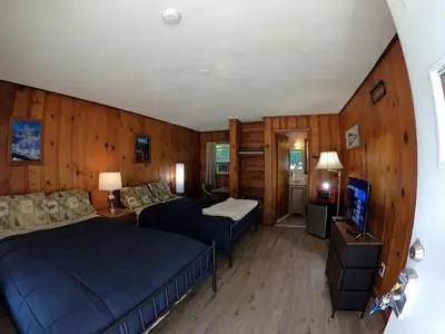 a bedroom with two beds and a television in it at Heart of the Berkshires Motel in Pittsfield