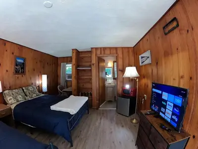 a bedroom with a bed and a flat screen tv at Heart of the Berkshires Motel in Pittsfield