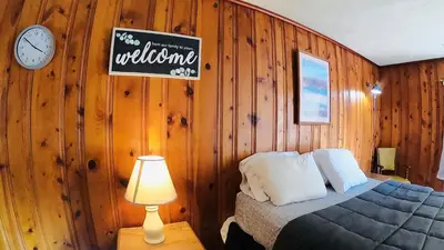 a bedroom with a bed and a clock on the wall at Heart of the Berkshires Motel in Pittsfield