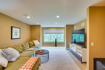 a living room with a couch and a flat screen tv at Stockbridge Retreat with Pool and Hot Tub! in Stockbridge